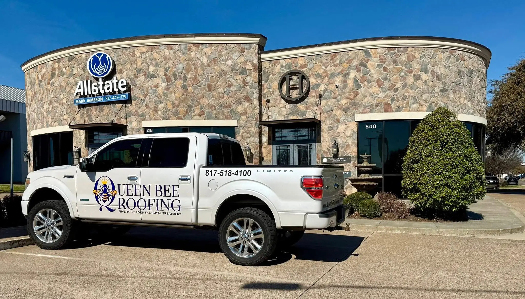 Queen Bee Roofing truck parked in front of a commercial building in Burleson, TX.